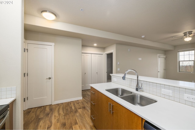 kitchen featuring a sink, brown cabinets, dark wood-type flooring, and light countertops