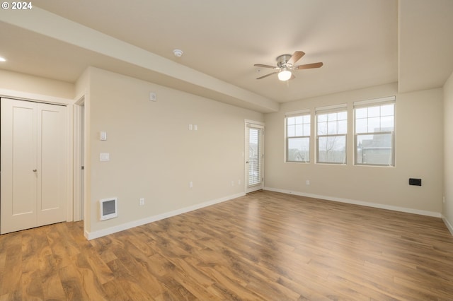 empty room with visible vents, baseboards, and wood finished floors