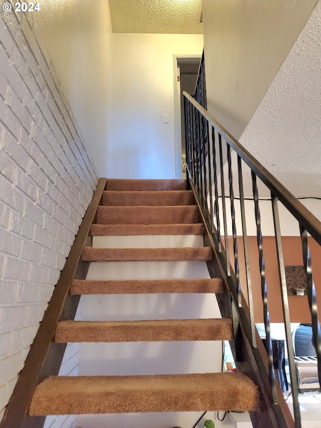 stairs with a textured ceiling