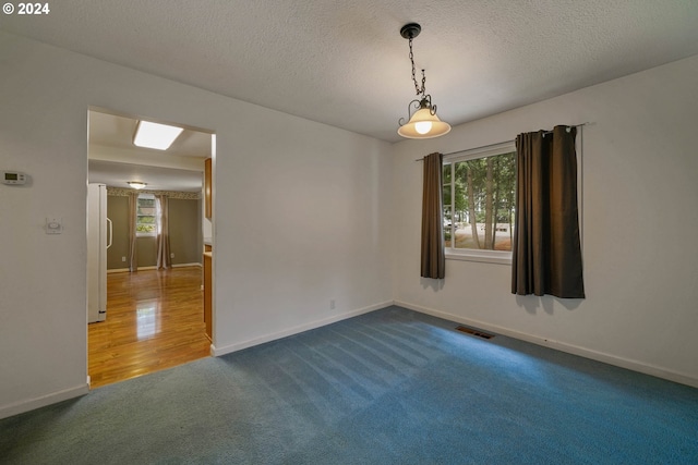 empty room with a textured ceiling and carpet floors