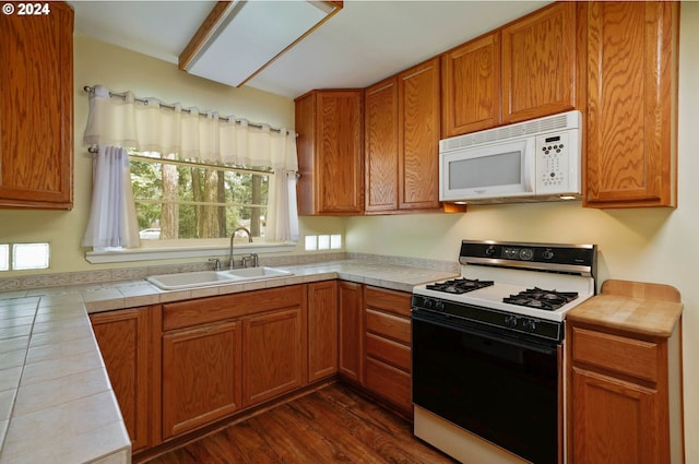 kitchen featuring sink, range with gas cooktop, dark wood-type flooring, and tile countertops