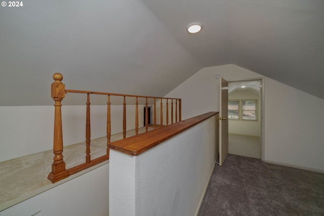 interior space featuring lofted ceiling and dark colored carpet