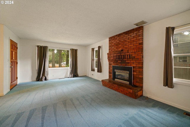 unfurnished living room with carpet flooring, a textured ceiling, and a fireplace