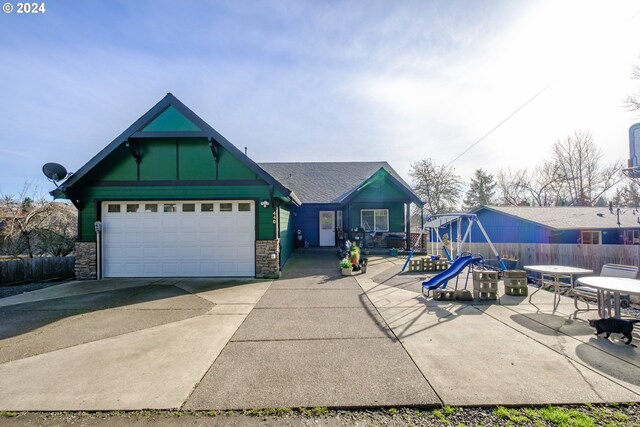 view of front of home featuring a playground and a garage