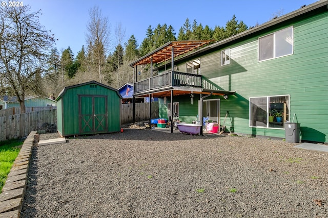 back of house with a deck and a storage shed