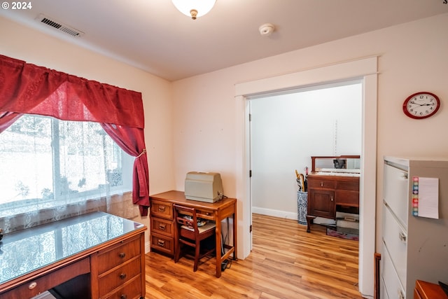 home office with light hardwood / wood-style flooring