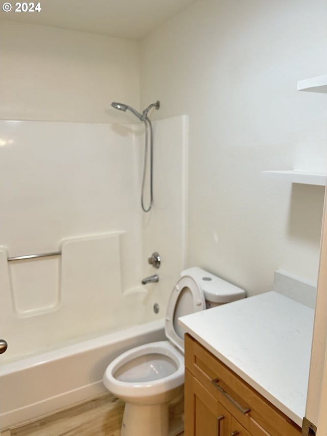 full bathroom with vanity, hardwood / wood-style floors, toilet, and washtub / shower combination