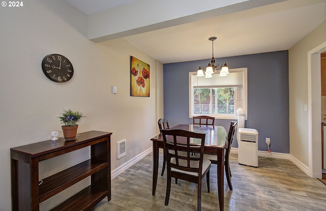 dining room featuring hardwood / wood-style floors and an inviting chandelier