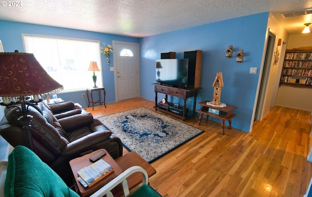 living room with hardwood / wood-style flooring and a textured ceiling