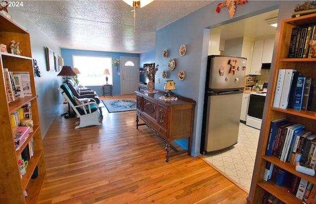 corridor featuring light hardwood / wood-style floors and a textured ceiling