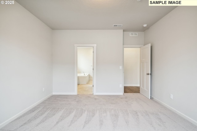 unfurnished bedroom with carpet, visible vents, and baseboards