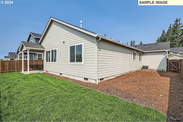 view of side of home with crawl space, central air condition unit, a fenced backyard, and a lawn