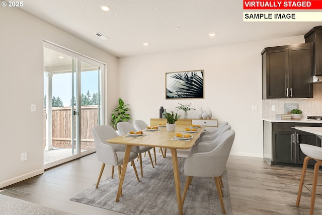 dining area featuring visible vents, baseboards, a textured ceiling, light wood-style floors, and recessed lighting