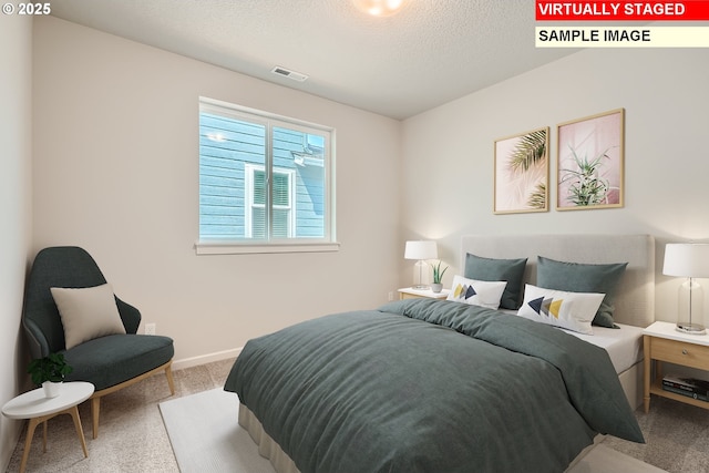 bedroom with carpet floors, baseboards, visible vents, and a textured ceiling