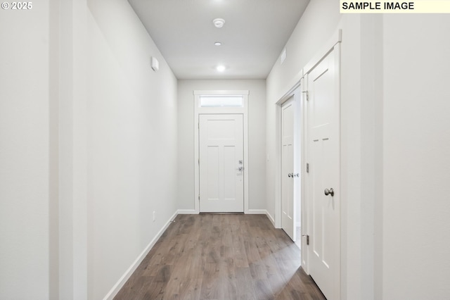 corridor featuring baseboards and wood finished floors