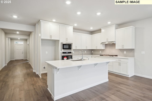 kitchen with stainless steel appliances, a sink, light countertops, and white cabinets