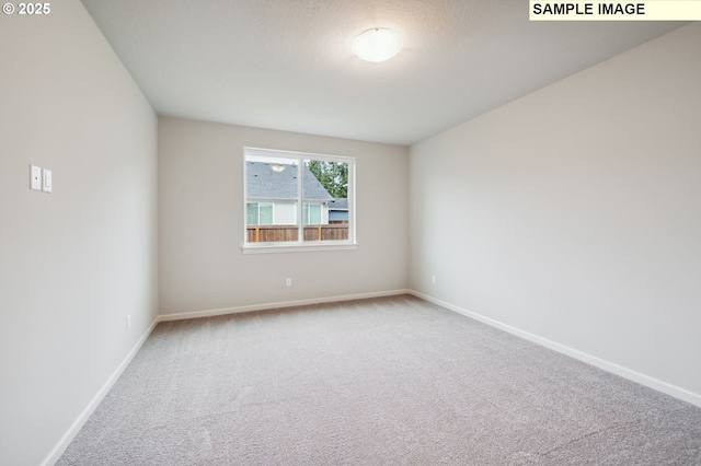 carpeted spare room with baseboards