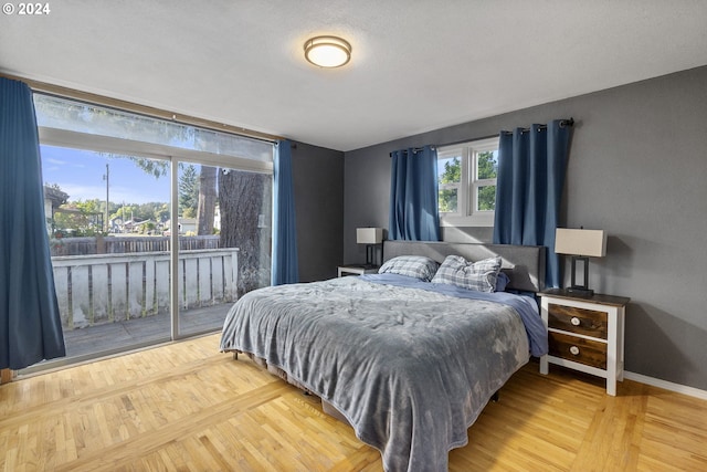 bedroom featuring access to outside and baseboards