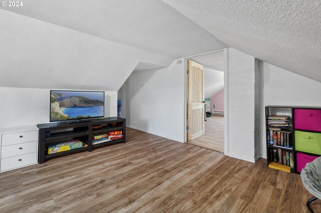 bonus room featuring vaulted ceiling and light hardwood / wood-style flooring