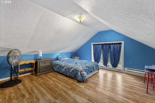 bedroom featuring a textured ceiling, a baseboard heating unit, vaulted ceiling, and wood finished floors