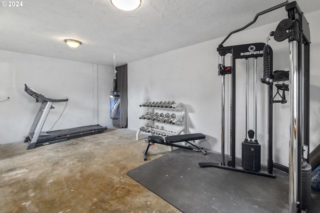 workout room featuring a textured ceiling and concrete flooring