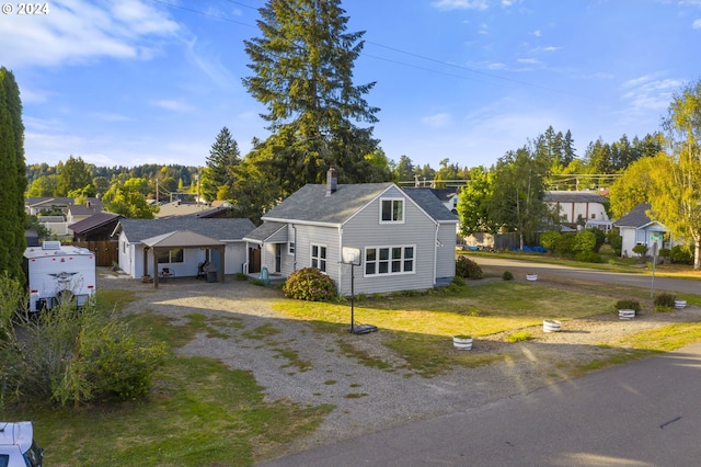 view of front facade with a front yard, driveway, and a chimney