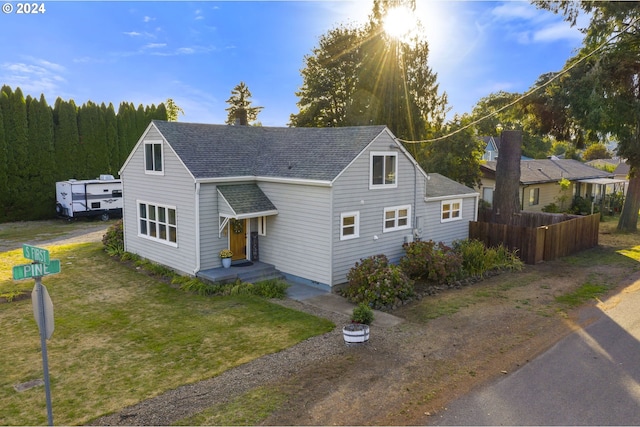 view of front of home featuring a front lawn and roof with shingles