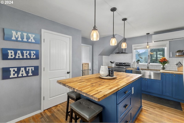 kitchen featuring blue cabinets, sink, decorative light fixtures, and tasteful backsplash