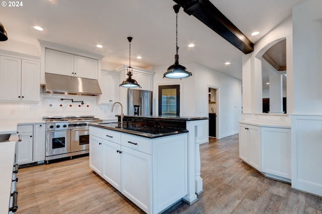 kitchen featuring white cabinetry, decorative light fixtures, high end appliances, and light wood-type flooring