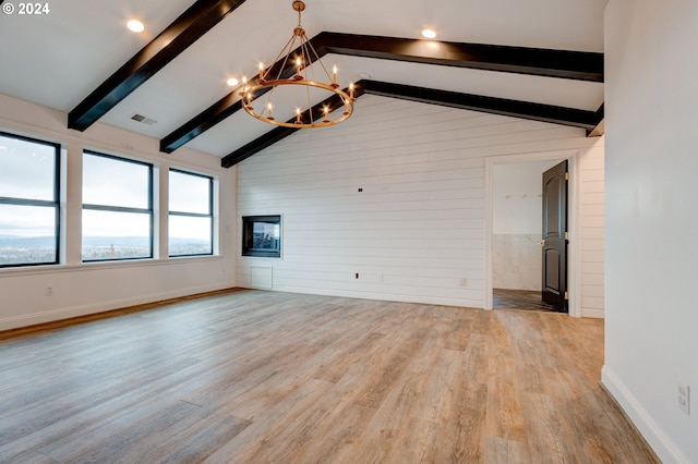 unfurnished living room with high vaulted ceiling, light wood-type flooring, a notable chandelier, and beamed ceiling