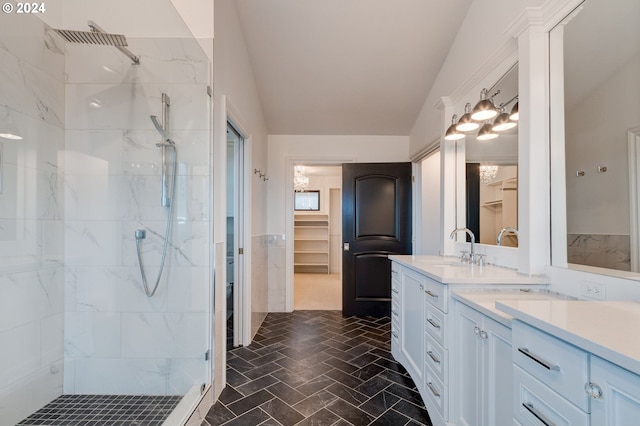 bathroom featuring tiled shower, vaulted ceiling, and vanity