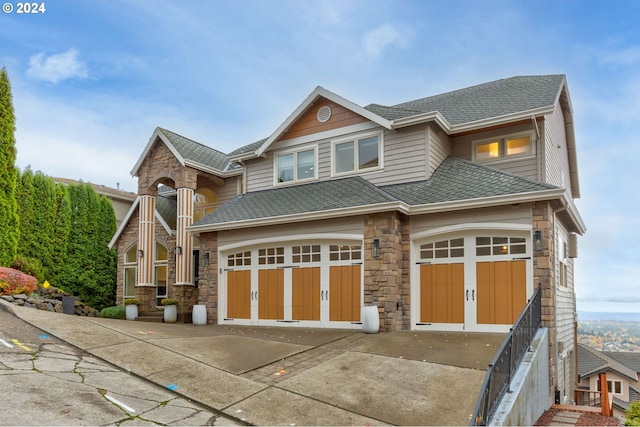 view of front of home featuring stone siding, a garage, concrete driveway, and a shingled roof