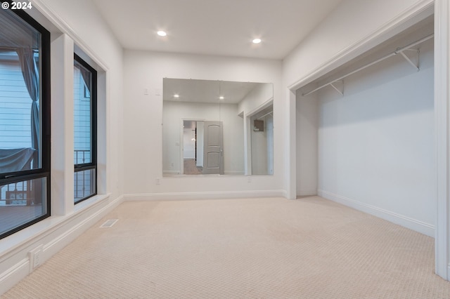 walk in closet with light colored carpet