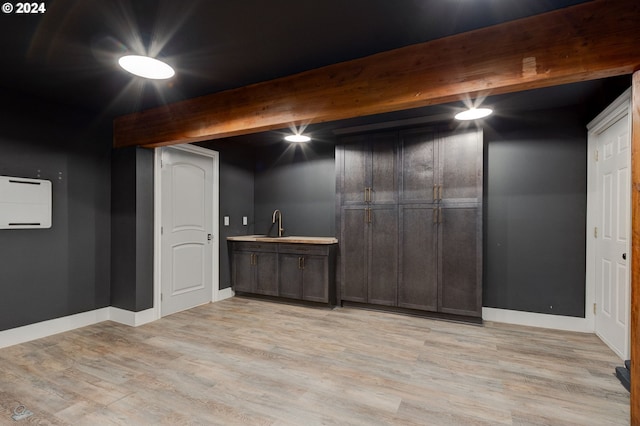 basement featuring light hardwood / wood-style flooring and sink