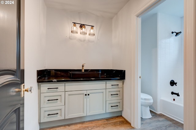 full bathroom featuring shower / bathing tub combination, vanity, hardwood / wood-style flooring, and toilet