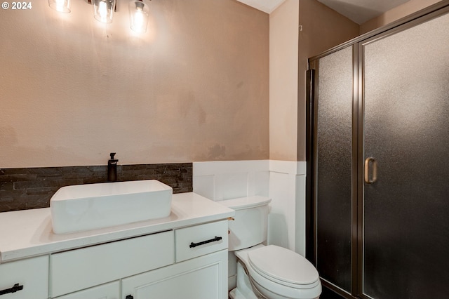 bathroom with walk in shower, vanity, and toilet