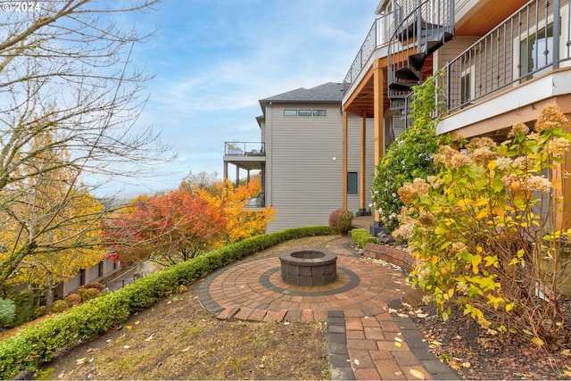 view of patio with a balcony and a fire pit