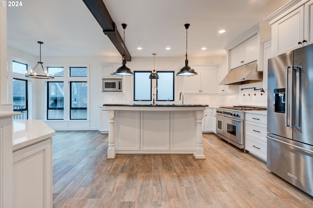 kitchen with tasteful backsplash, decorative light fixtures, white cabinets, high end appliances, and light hardwood / wood-style flooring