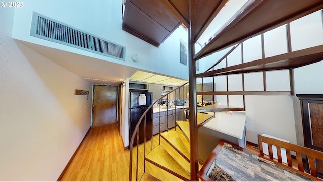 staircase featuring hardwood / wood-style flooring and a high ceiling