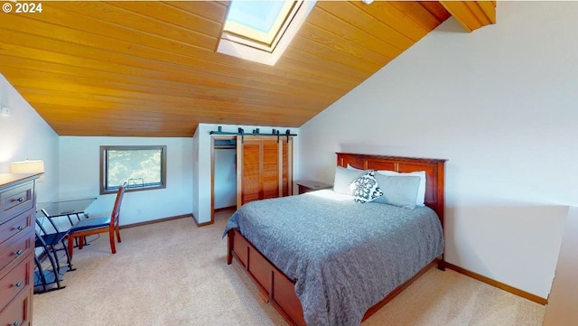 bedroom featuring baseboards, a barn door, lofted ceiling with skylight, and light colored carpet