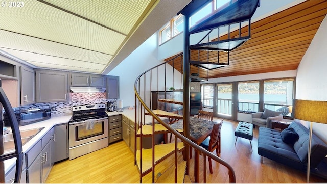 kitchen featuring stainless steel range with electric stovetop, light hardwood / wood-style floors, backsplash, and gray cabinets