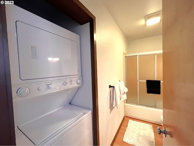 washroom with laundry area, light wood finished floors, and stacked washing maching and dryer