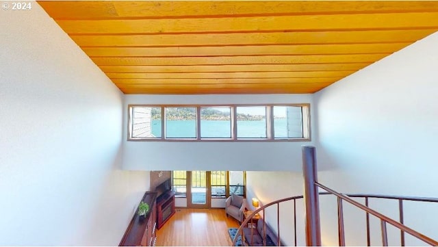 staircase with lofted ceiling, wooden ceiling, and wood finished floors