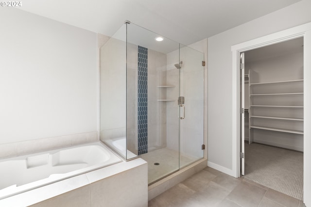 bathroom with shower with separate bathtub and tile patterned floors