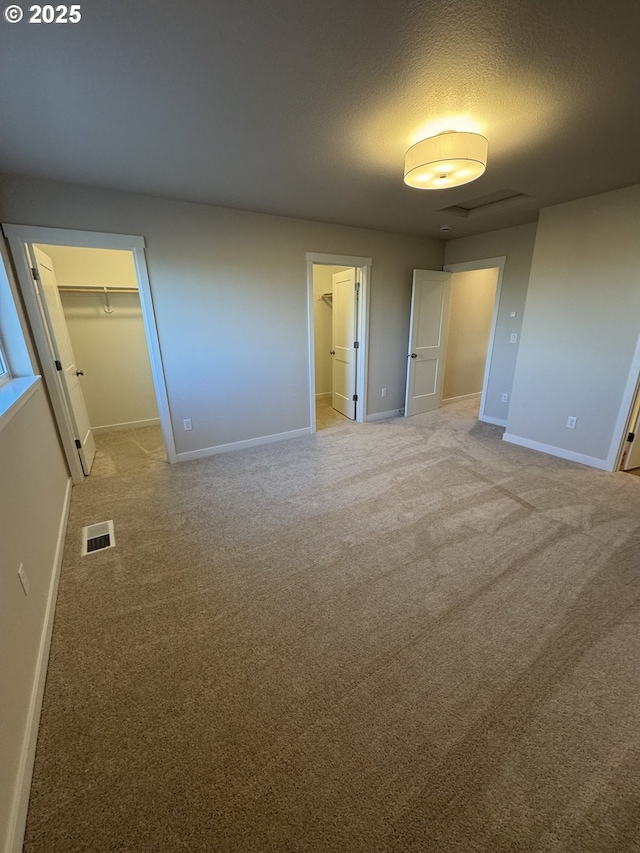 347 SE Shetterly Dr, Dallas, OR 97338 - unfurnished bedroom featuring a textured ceiling, a closet, carpet flooring, and a walk in closet