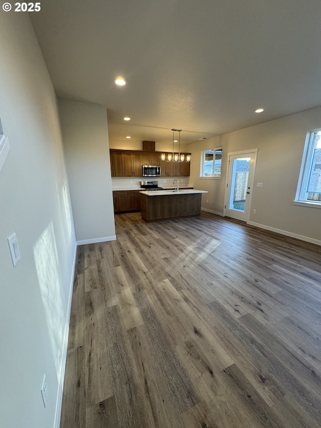 347 SE Shetterly Dr, Dallas, OR 97338 - kitchen featuring a center island with sink, a wealth of natural light, hardwood / wood-style floors, and decorative light fixtures