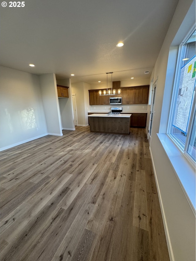 347 SE Shetterly Dr, Dallas, OR 97338 - kitchen featuring hardwood / wood-style flooring, a kitchen island, stove, and decorative light fixtures