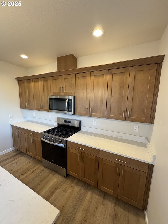 347 SE Shetterly Dr, Dallas, OR 97338 - kitchen with light wood-type flooring, stainless steel appliances, and light stone countertops