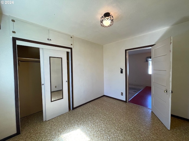 unfurnished bedroom featuring a textured ceiling and a closet