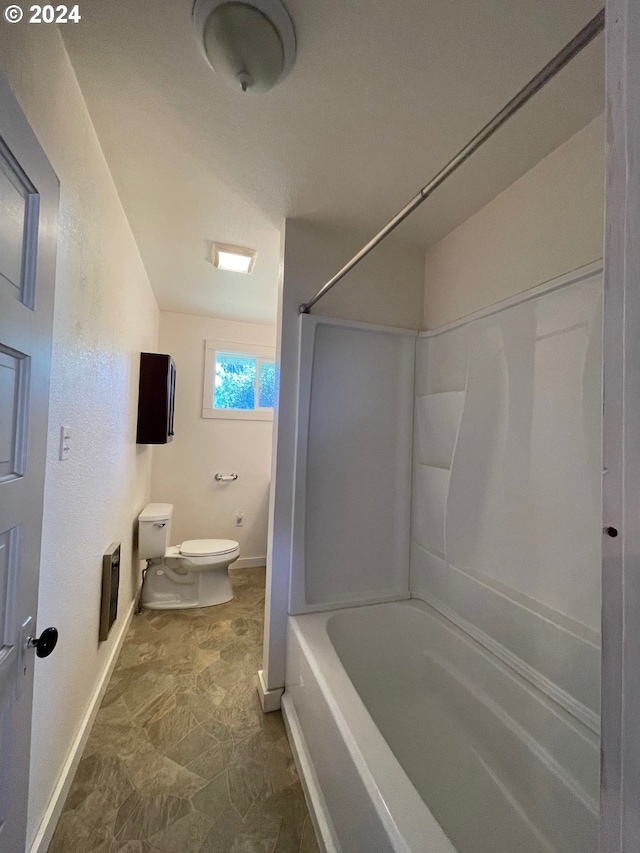 bathroom with shower / washtub combination and toilet